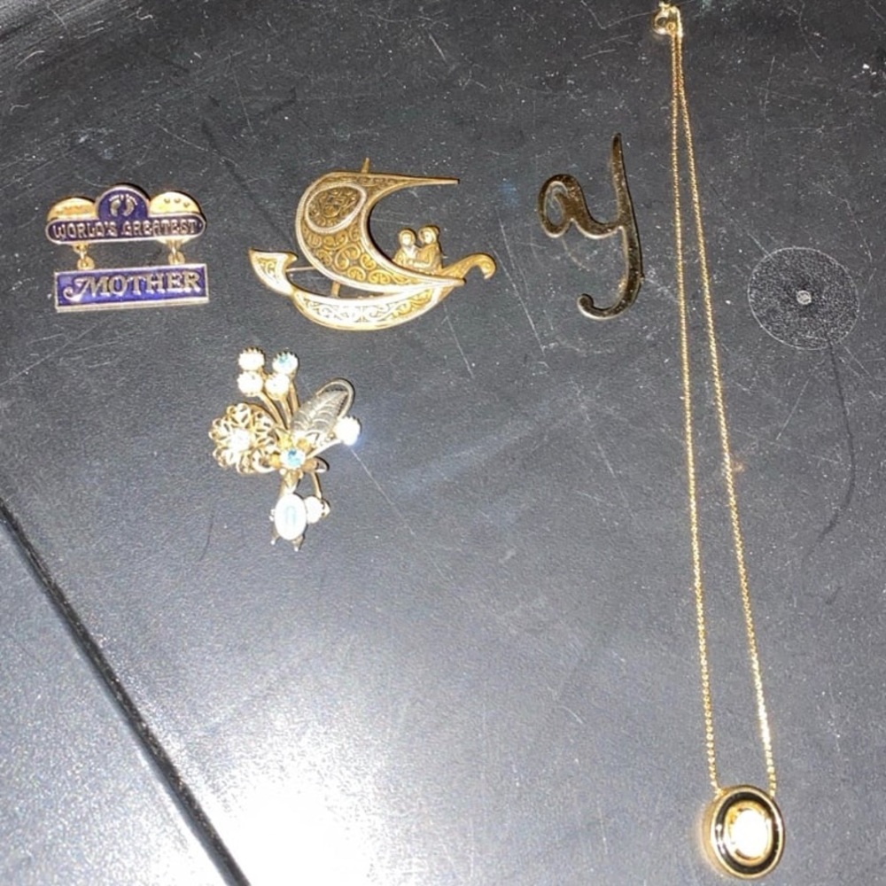 4 gold tone pins and a gold tone opal necklace